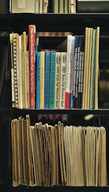 a bookshelf filled with lots of books and papers
