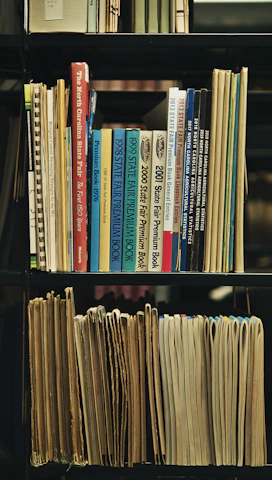 a bookshelf filled with lots of books and papers