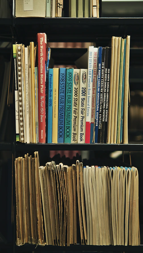 a bookshelf filled with lots of books and papers