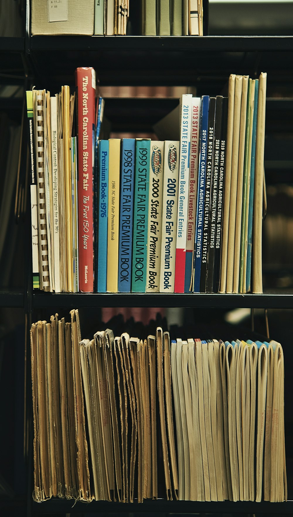 a bookshelf filled with lots of books and papers