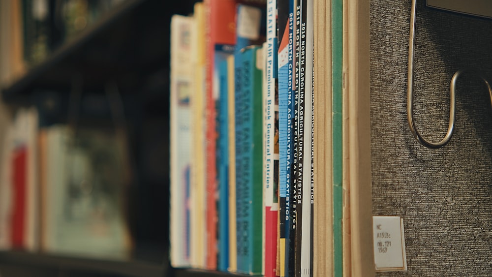 uma fileira de livros sentados em cima de uma estante de livros