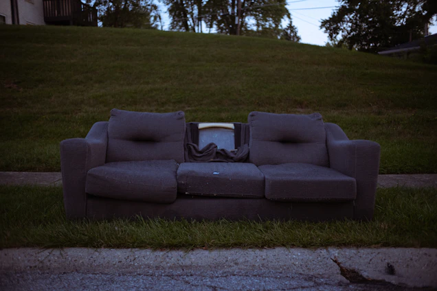 A friendly West GA Property Services crew member lifting a bulky sofa outside a Temple, GA home.