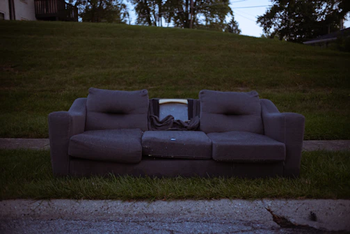 Customer handing over a small couch to the driver outside a Charlotte home.