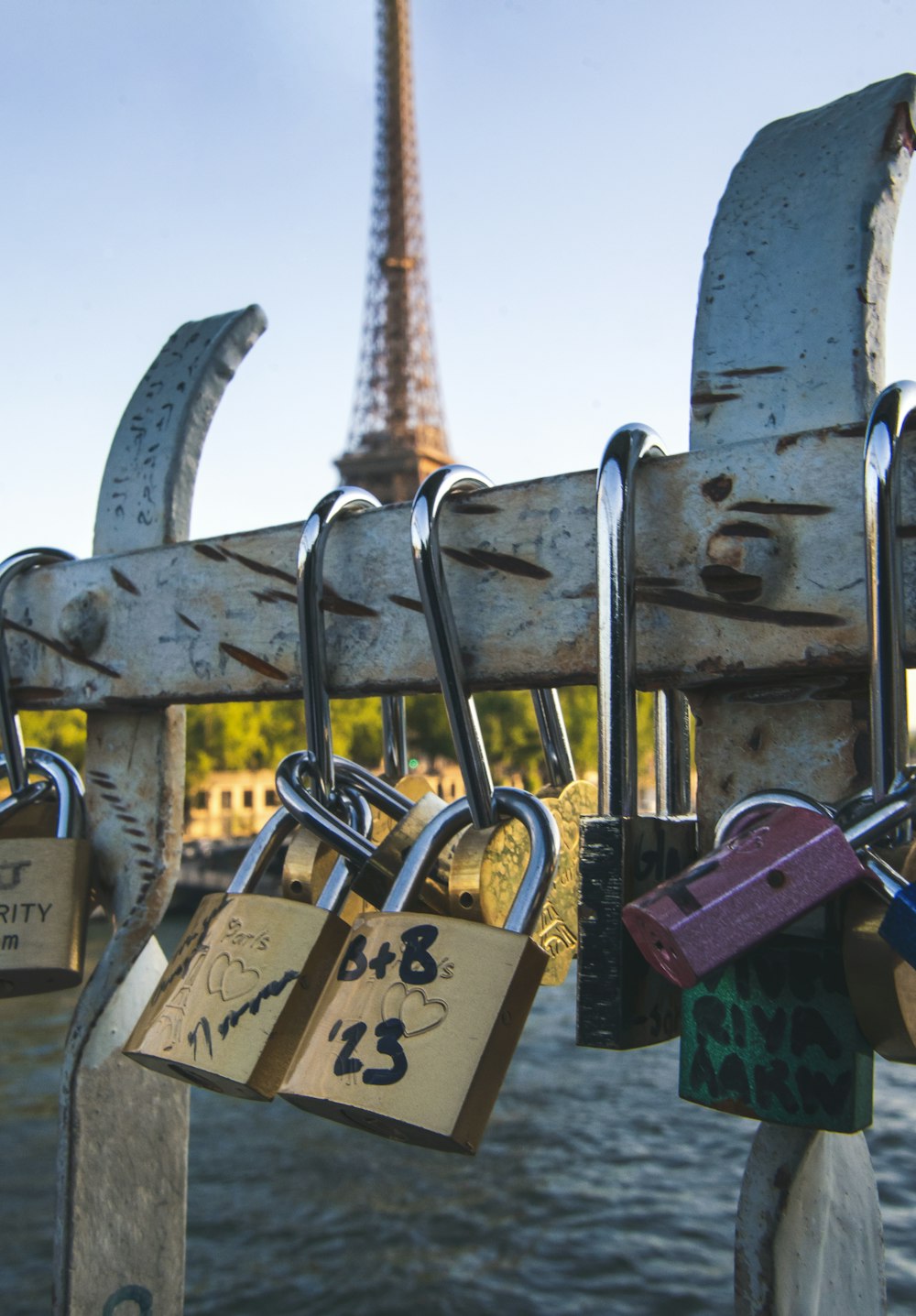 a bunch of padlocks attached to a fence with the eiffel tower