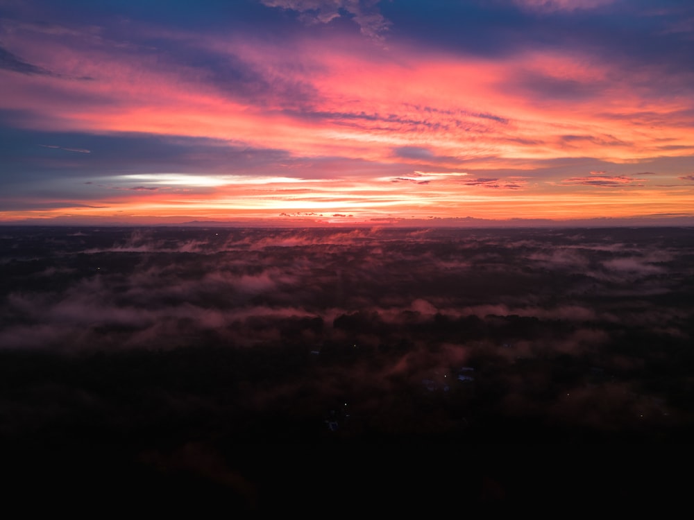 the sun is setting over the clouds in the sky