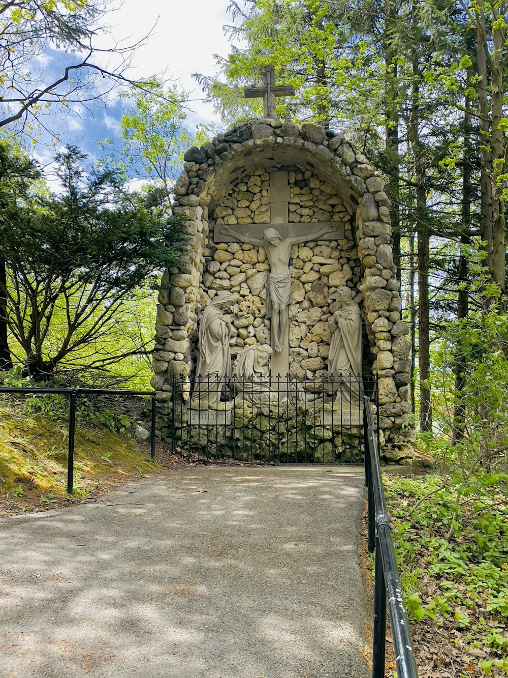 Une statue d’un crucifix sur un mur de pierre