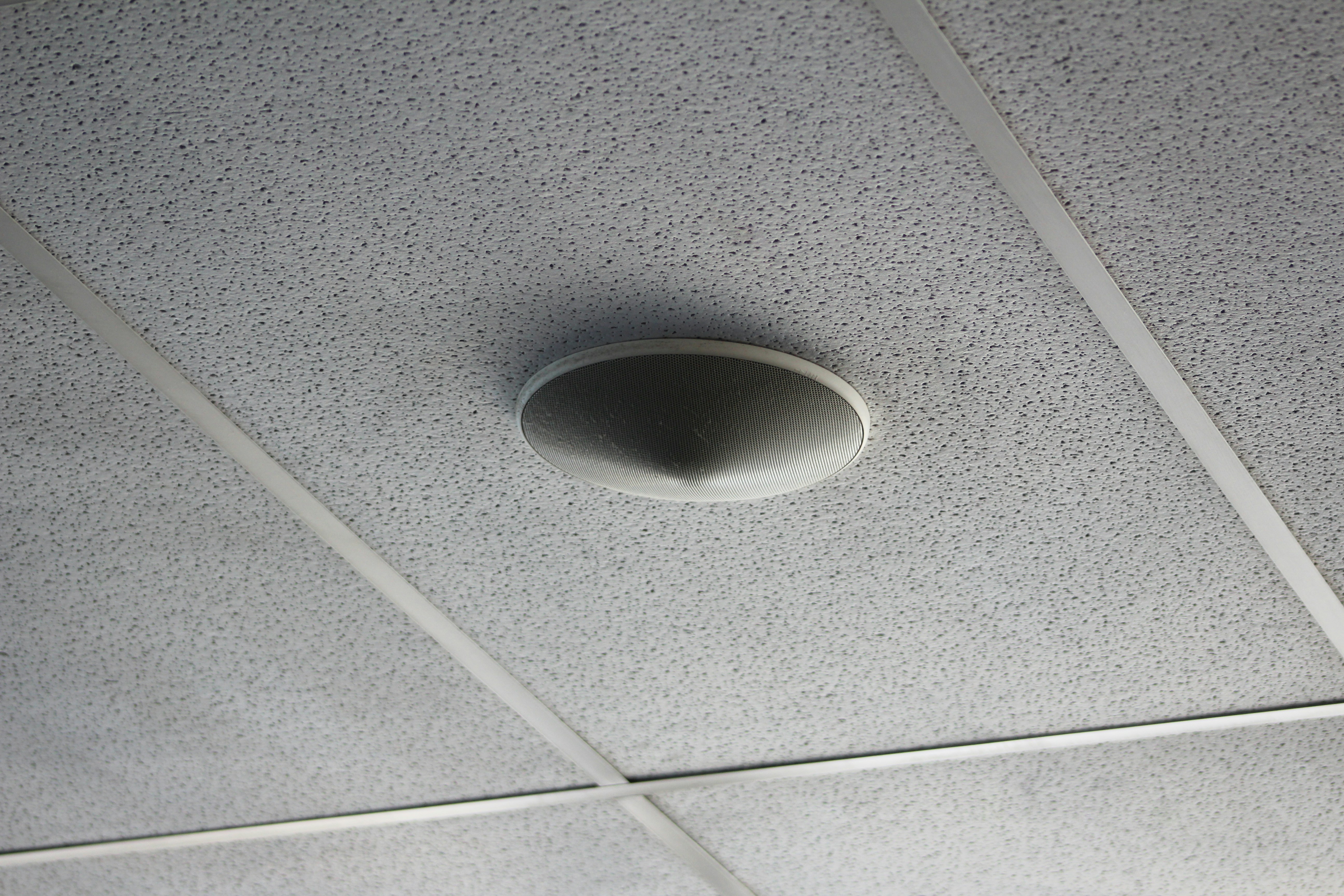 close up of a smoke detector on a ceiling near an HVAC vent - what to do when your hvac breaks down unexpectedly
