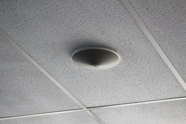 Close-up of smoke alarm installation in a ceiling.