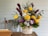 A vibrant flower board arrangement with yellow and white flowers on a wooden stand