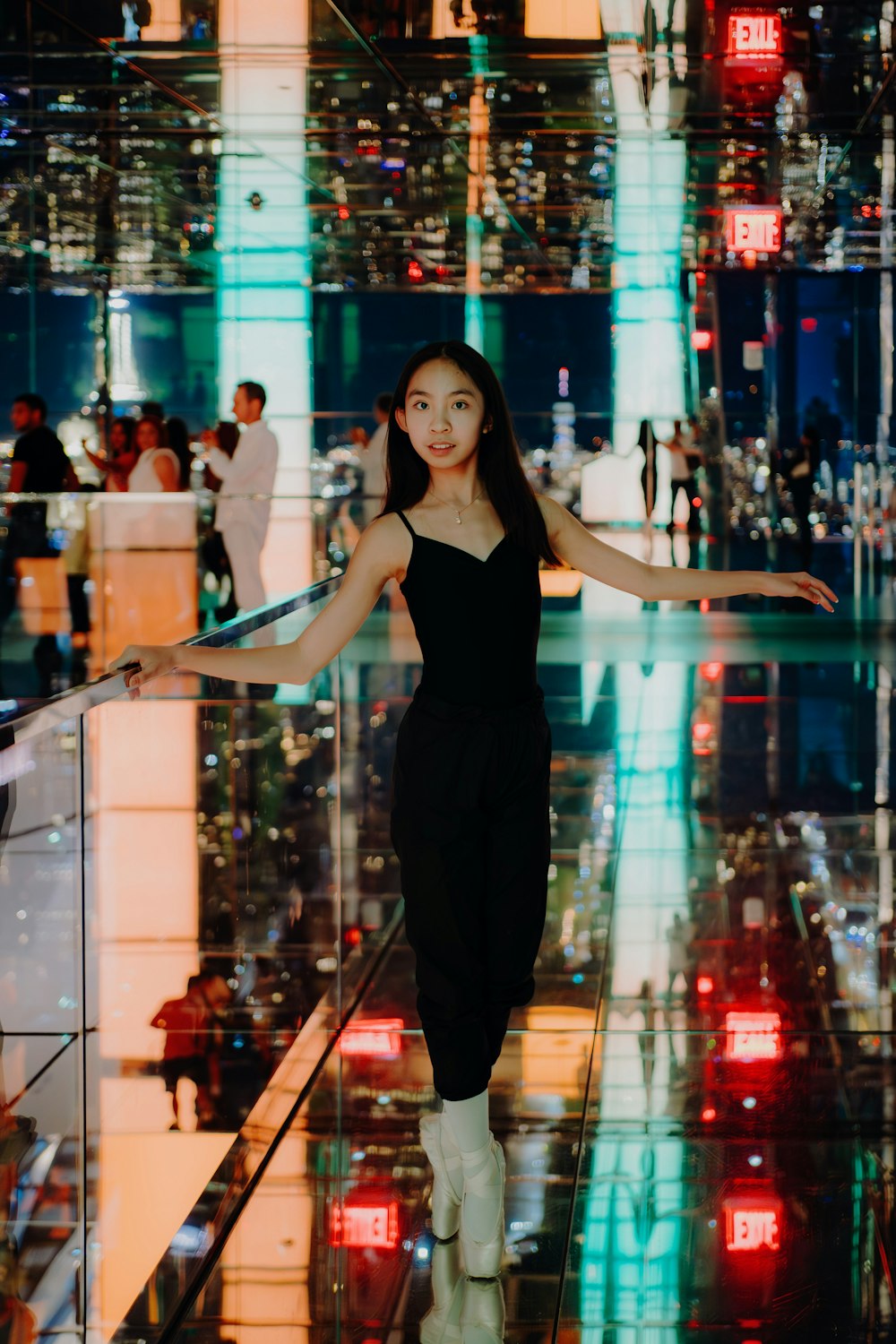 a woman in a black dress standing on a glass floor