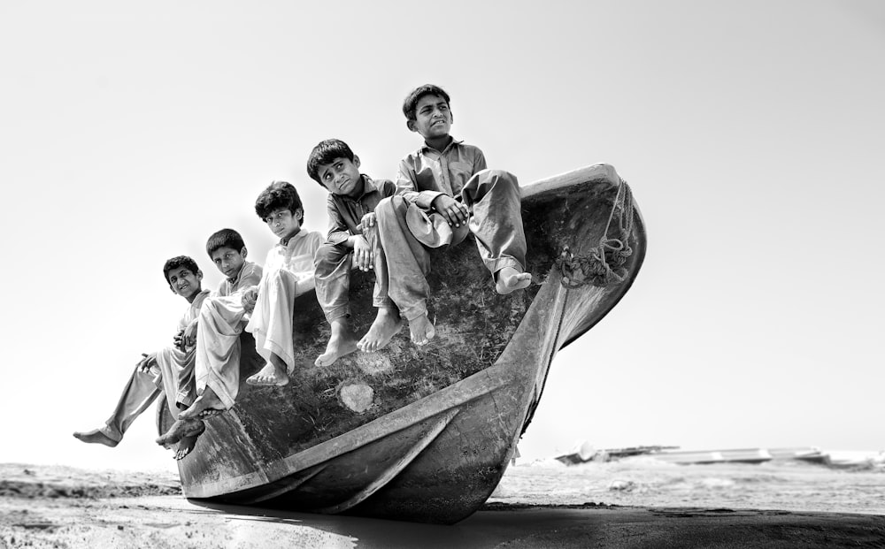 a group of boys sitting on top of a boat