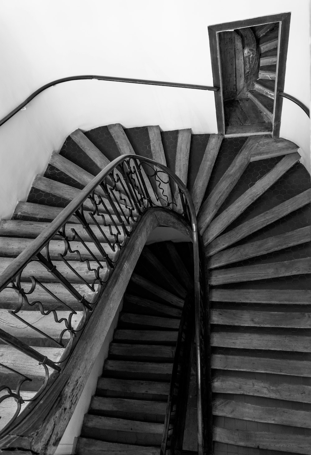 a black and white photo of a spiral staircase