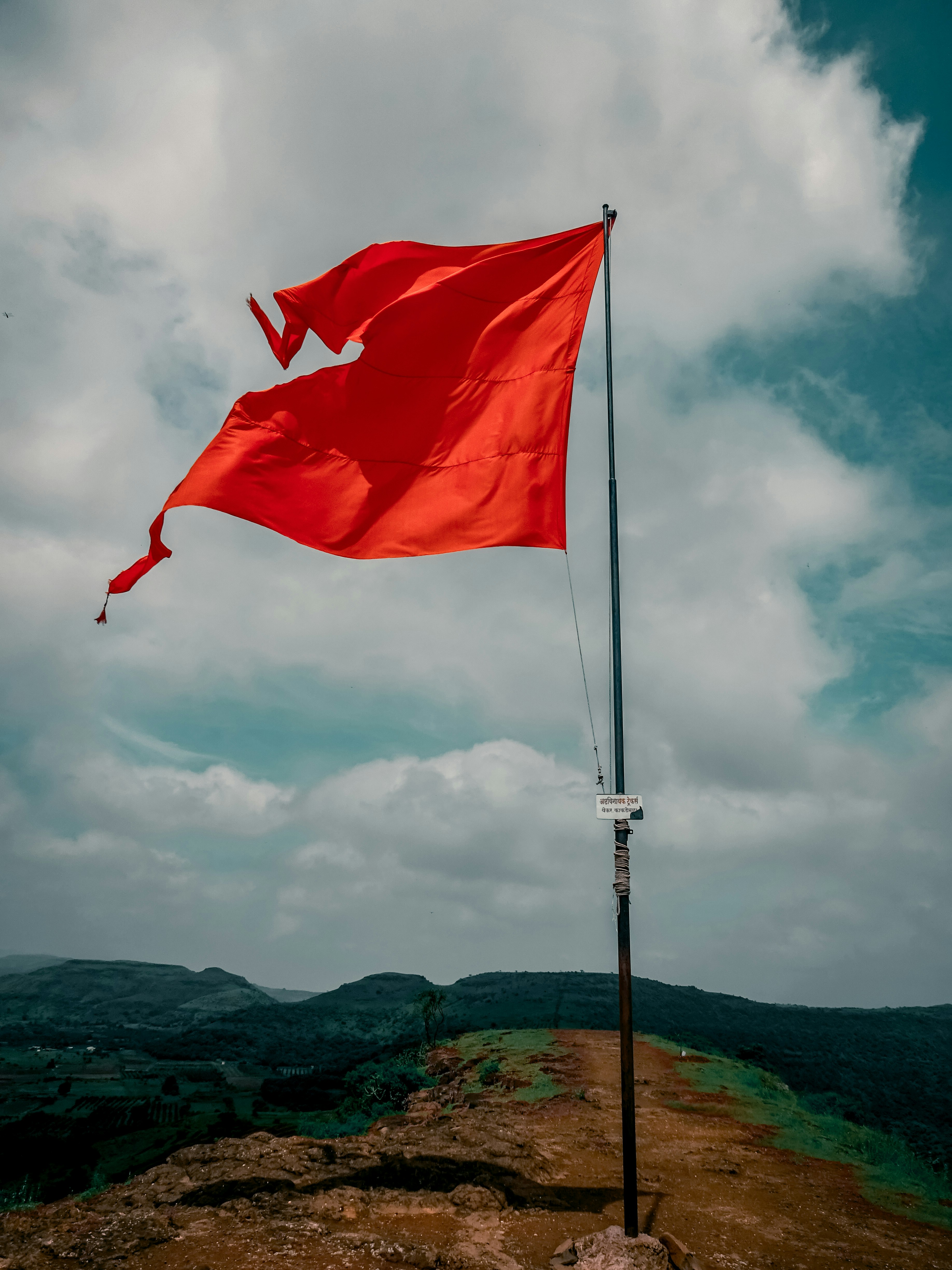 A red flag flying on top of a mountain photo – Free Flag Image on Unsplash