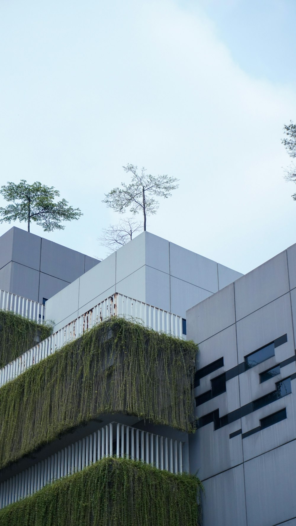 a very tall building with a bunch of plants growing on it