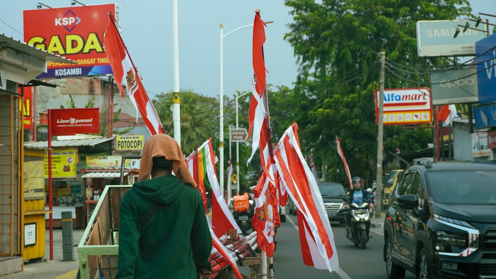 a person walking down a street with many flags