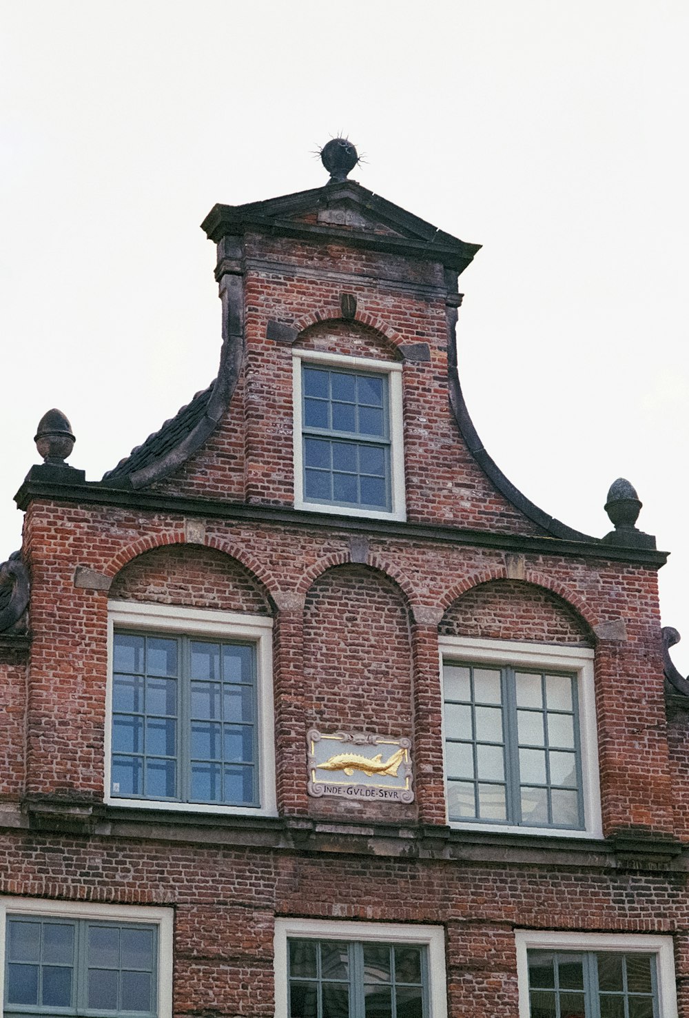 Un alto edificio in mattoni con un orologio sul lato