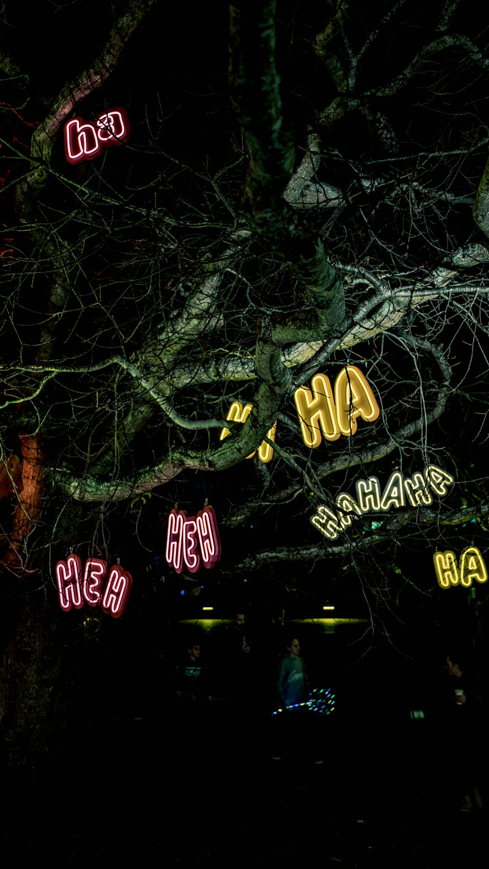 a group of neon signs hanging from the side of a tree