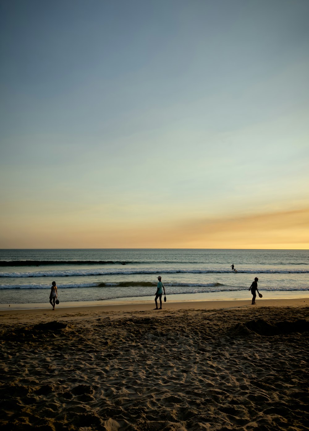 a group of people standing on top of a sandy beach