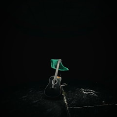 An artistic shot of a guitar resting on a stool.