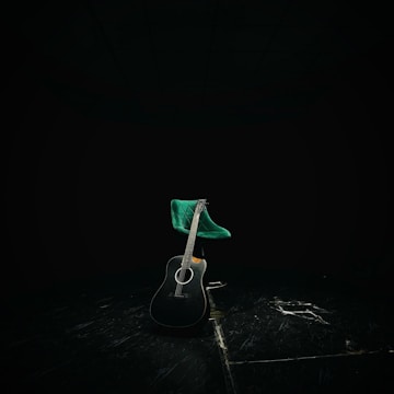 An artistic shot of a guitar resting on a stool.