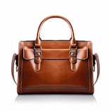 a brown leather handbag on a white background