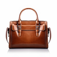a brown leather handbag on a white background