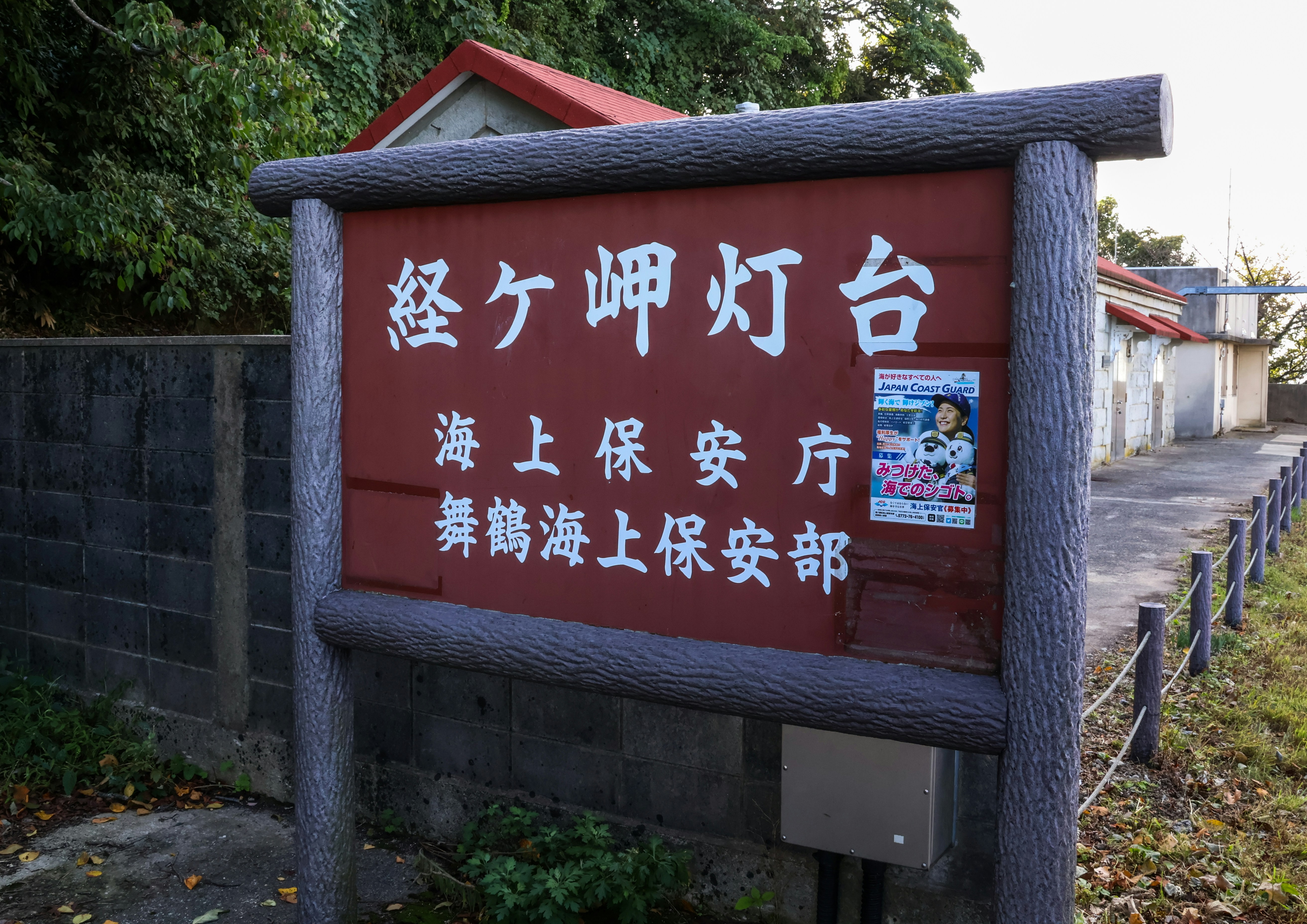 a sign in a foreign language in front of a fence