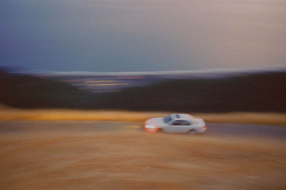 a blurry photo of a car driving down a road