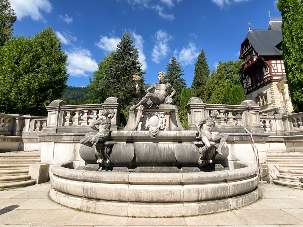 a stone fountain with statues on top of it