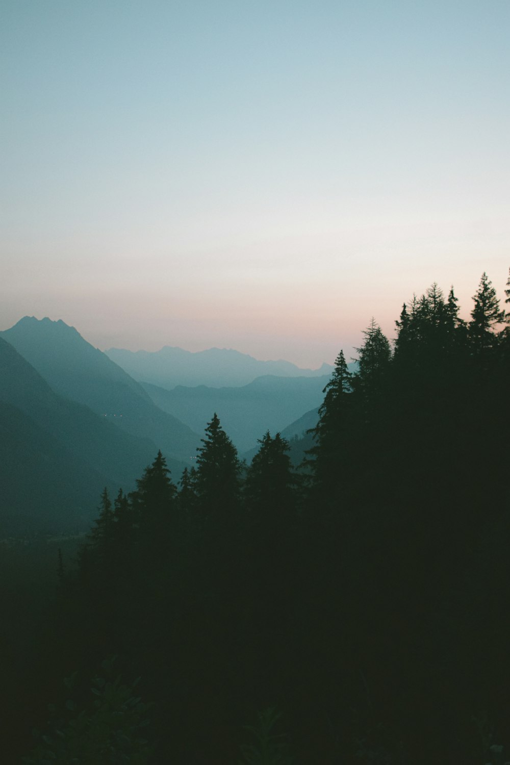 a view of a mountain range with trees in the foreground