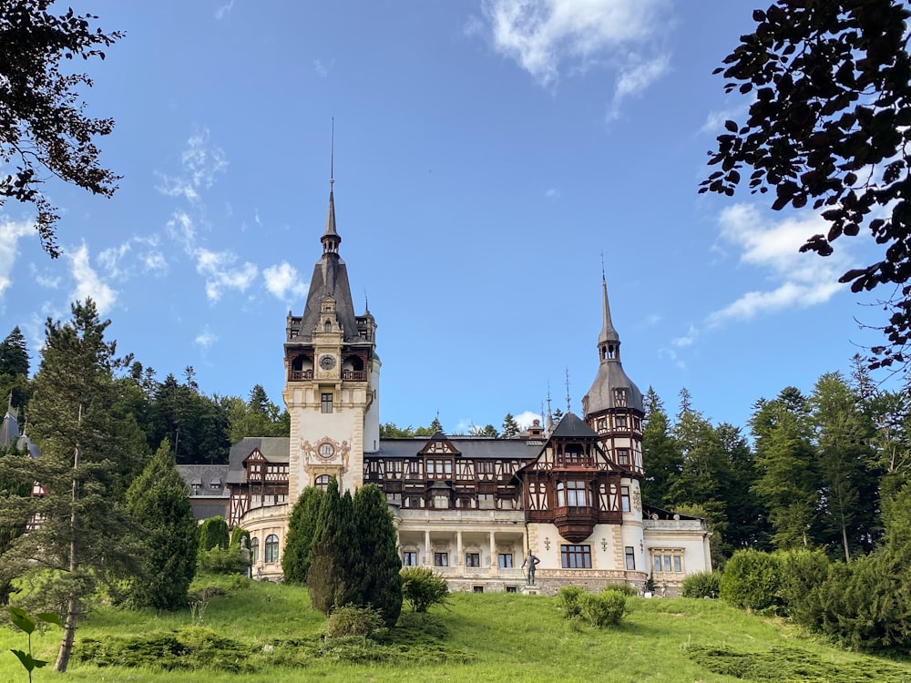 um grande edifício sentado no topo de uma colina verde exuberante