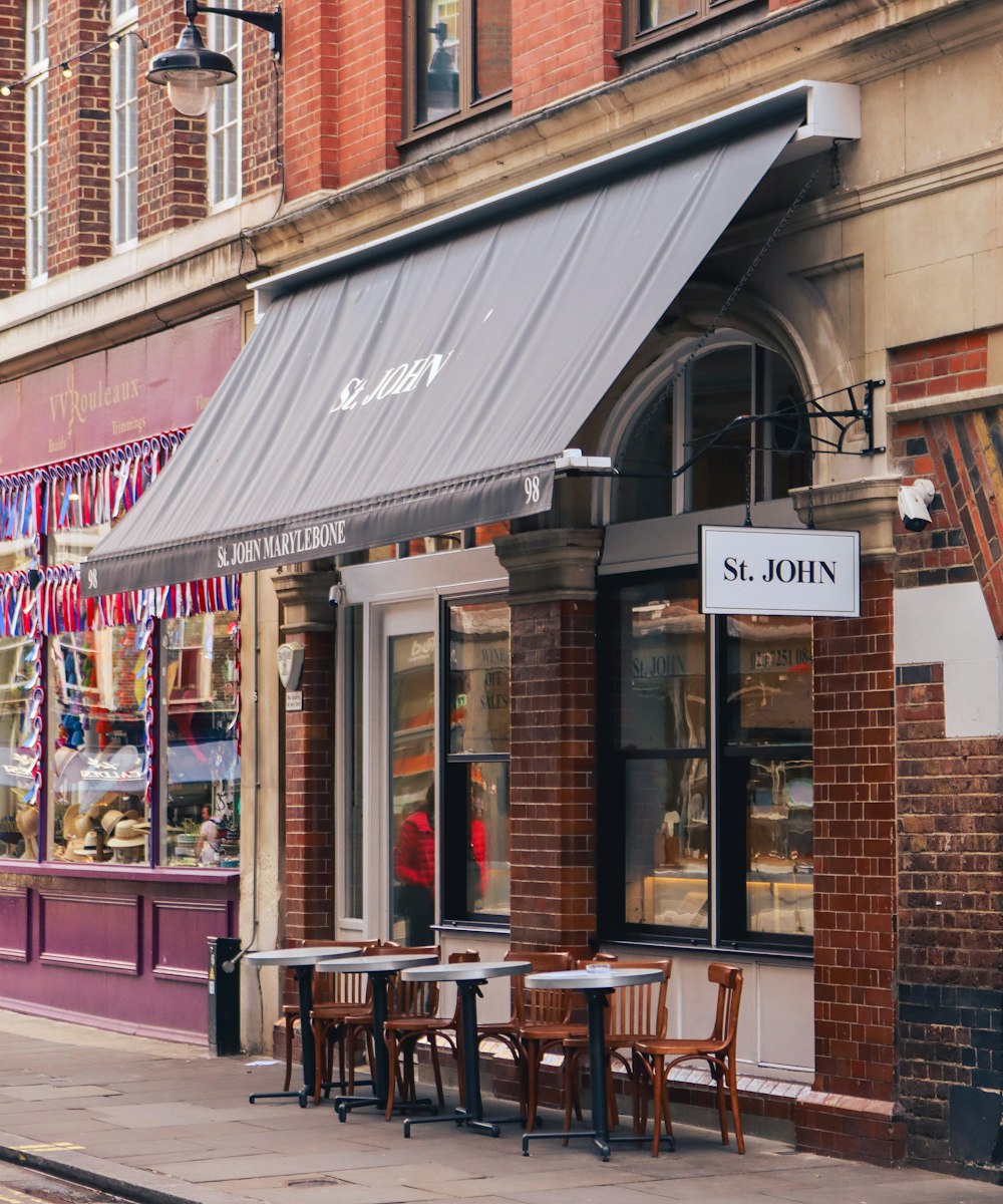 a store front with tables and chairs in front of it