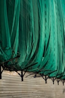 Hand installing a custom-sized mosquito net onto a metal frame