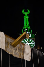A panoramic view from a hotel balcony overlooking the illuminated Kaaba at night.