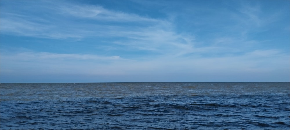 a large body of water sitting under a blue sky