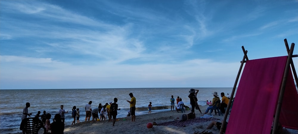 a group of people standing on top of a sandy beach