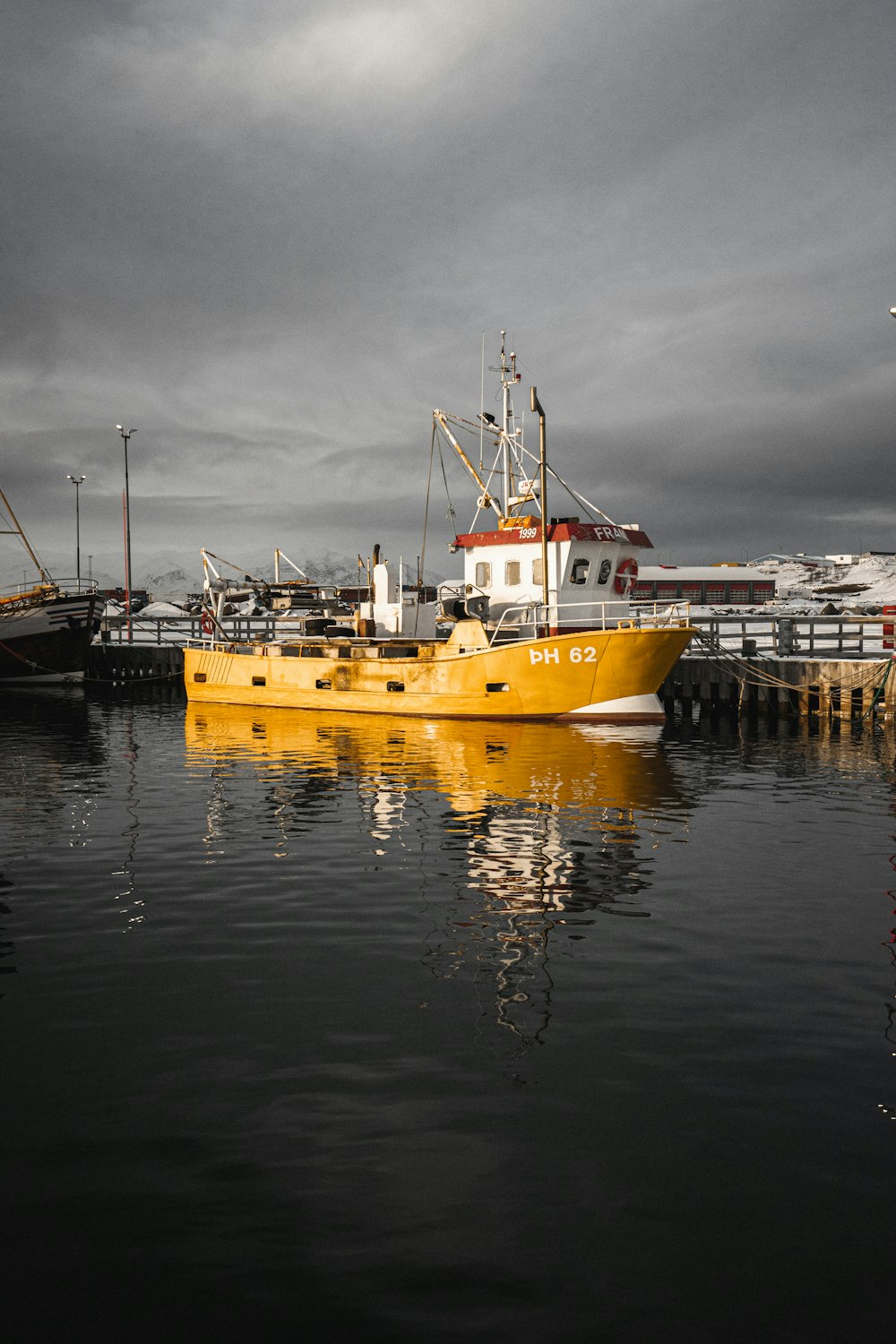 ein gelbes Boot im Wasser in der Nähe eines Docks