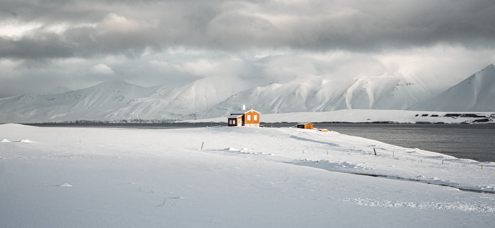 a small house in the middle of a snowy field