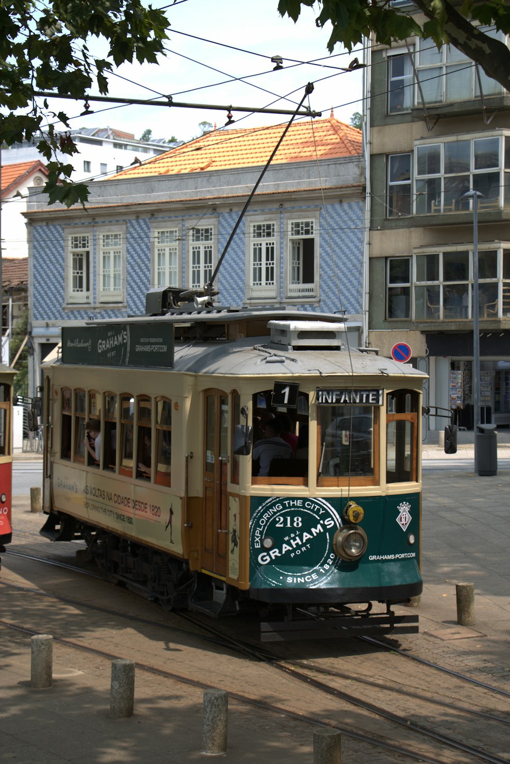 a trolley car traveling down a street next to a tall building