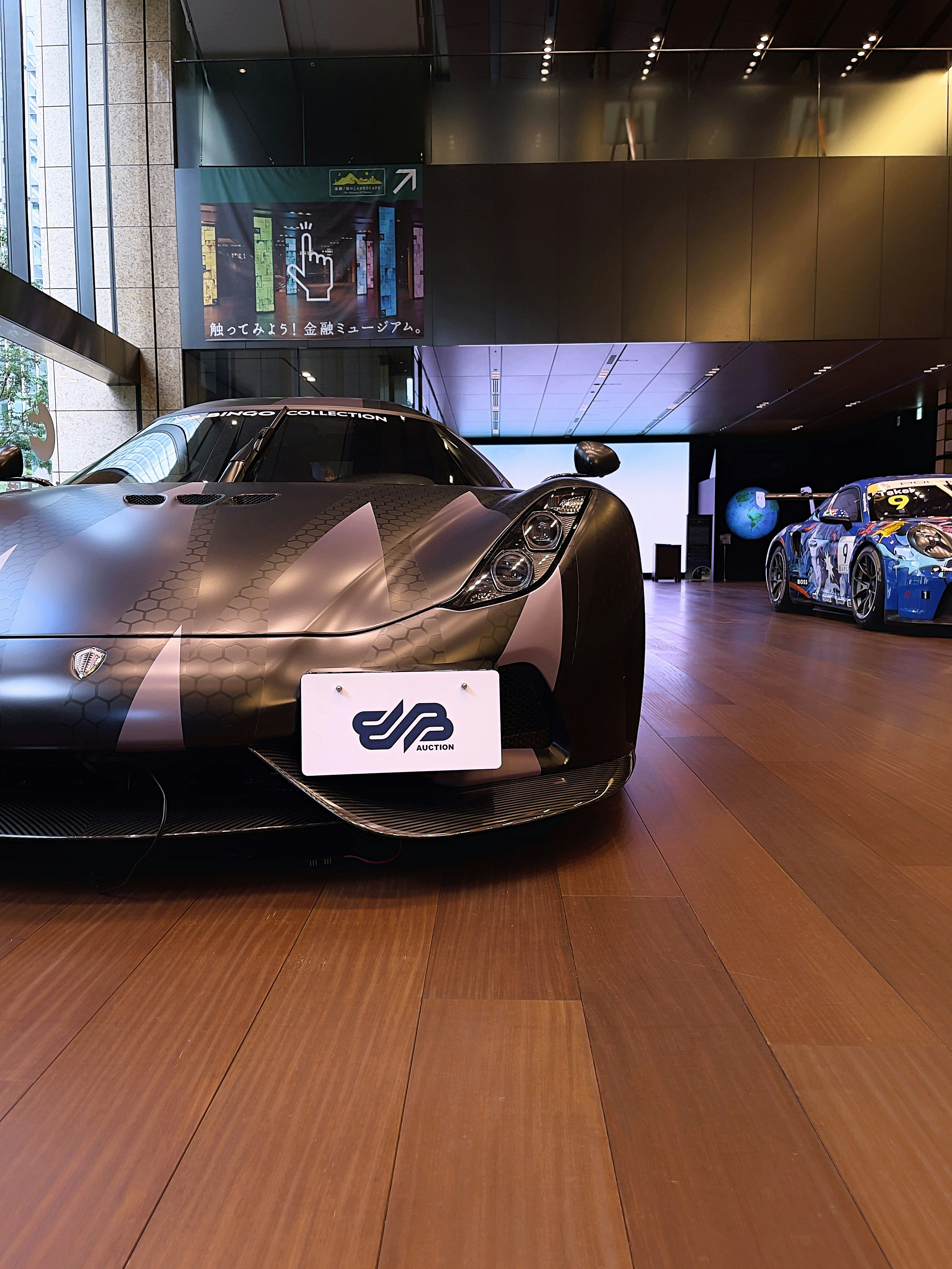 A black sports car on display in a building photo – Free Car Image on ...