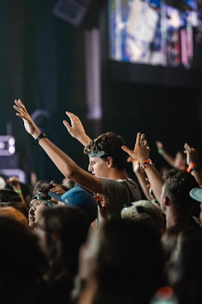 Audience enjoying a concert with hands raised in excitement.