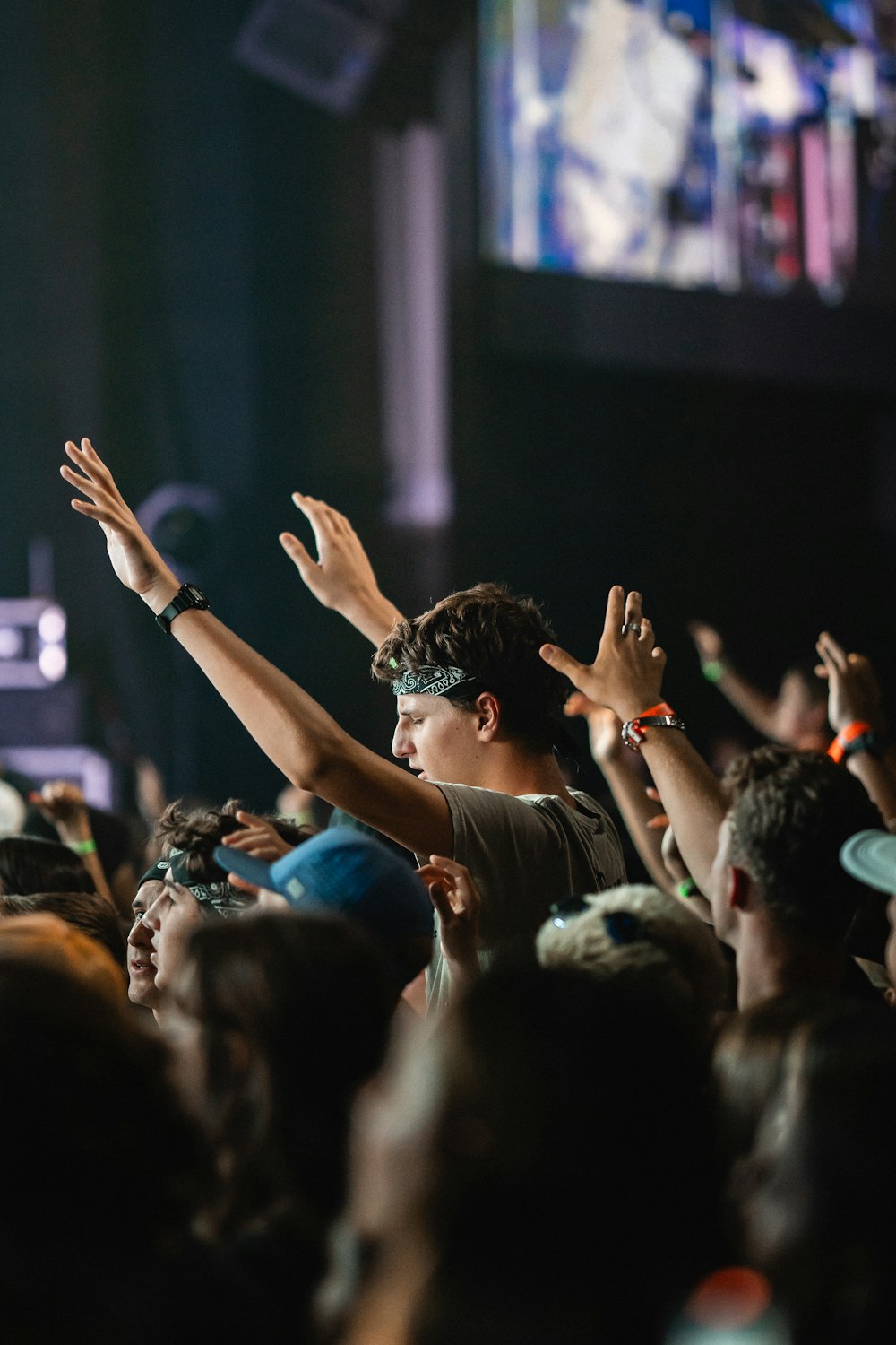 a crowd of people at a concert with their hands in the air