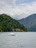 A serene boat gliding on the calm waters of Lake Maggiore at sunset, framed by lush green shores.