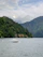 A serene boat gliding on the calm waters of Lake Maggiore at sunset, framed by lush green shores.