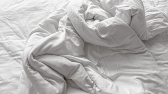 A close-up view of plush pillows stacked on a soft bedspread.