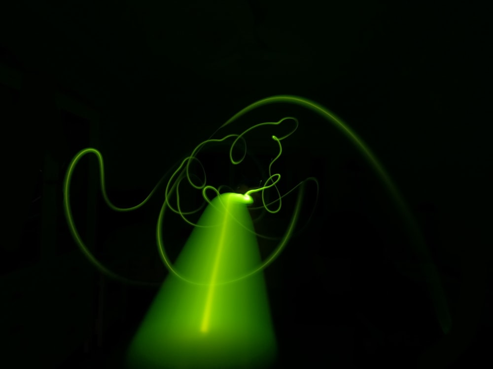 a green light is shining on a black background