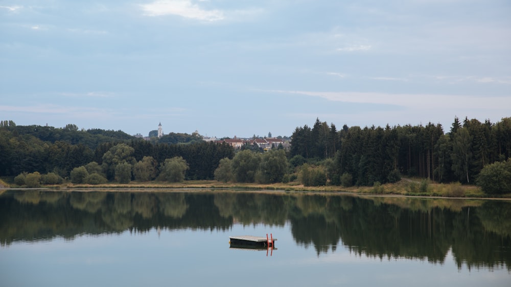 a small boat floating on top of a lake