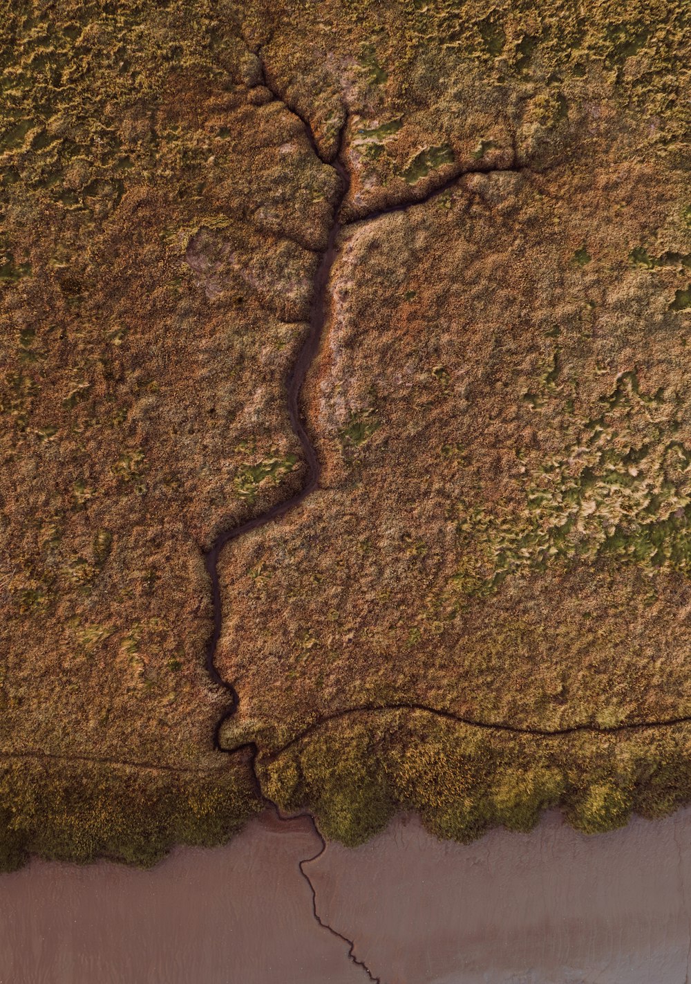 an aerial view of a river running through a field