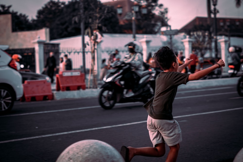a young boy is playing with a ball in the street