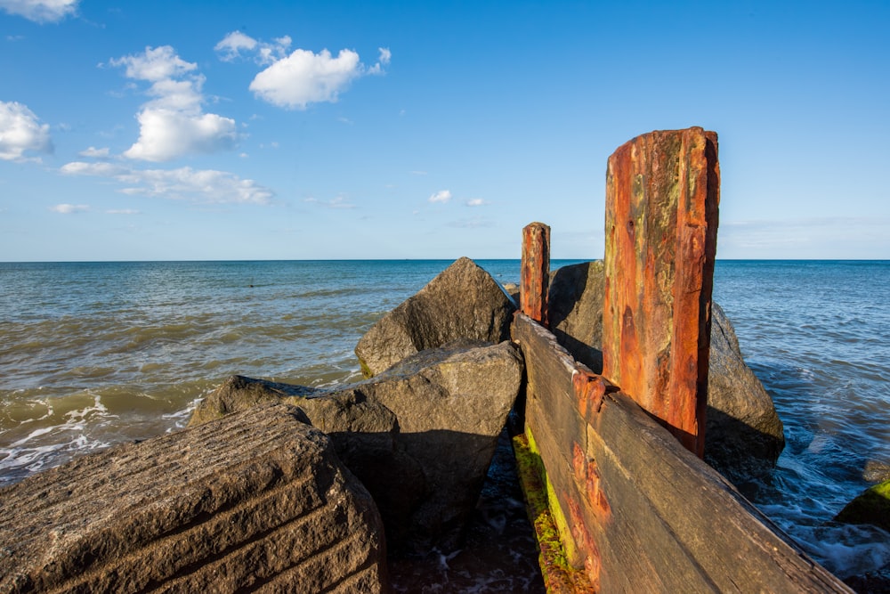 a rusted out piece of metal sitting on top of a rock near the ocean